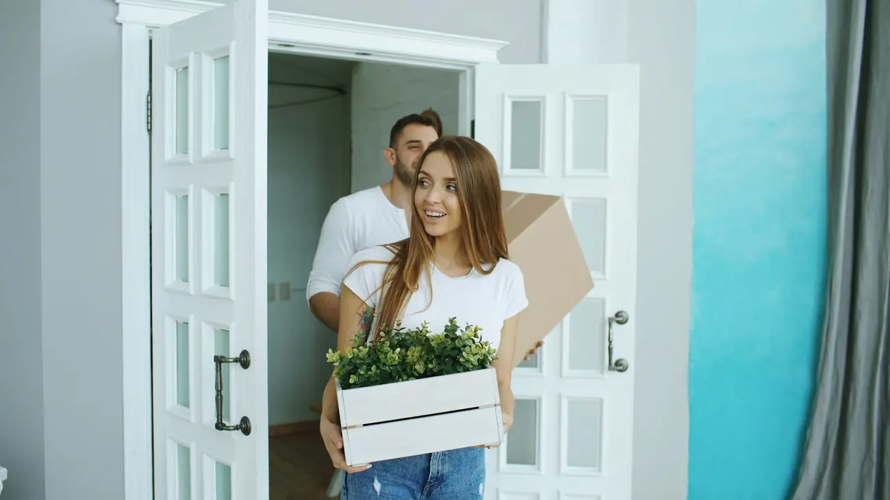 A couple carrying boxes into their new home